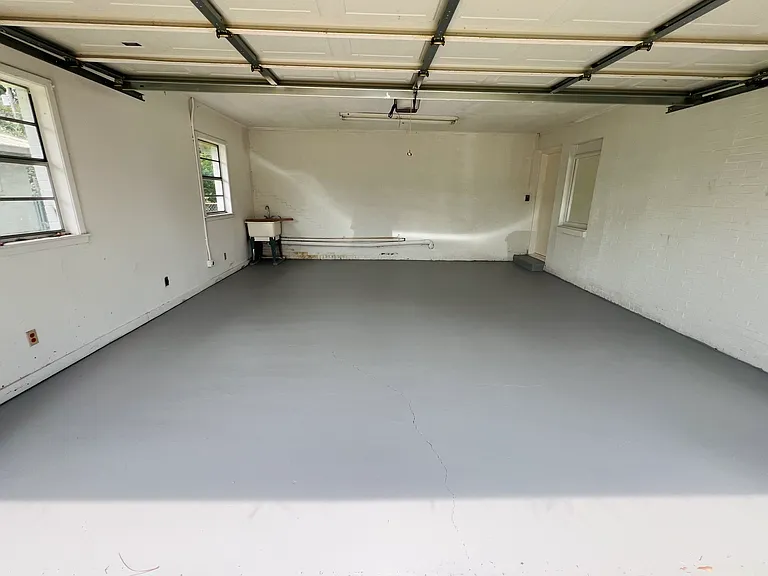 Oversized epoxy garage with a work sink.