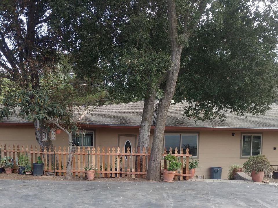 Private entry from one of two parking areas with shade trees and rock garden.;