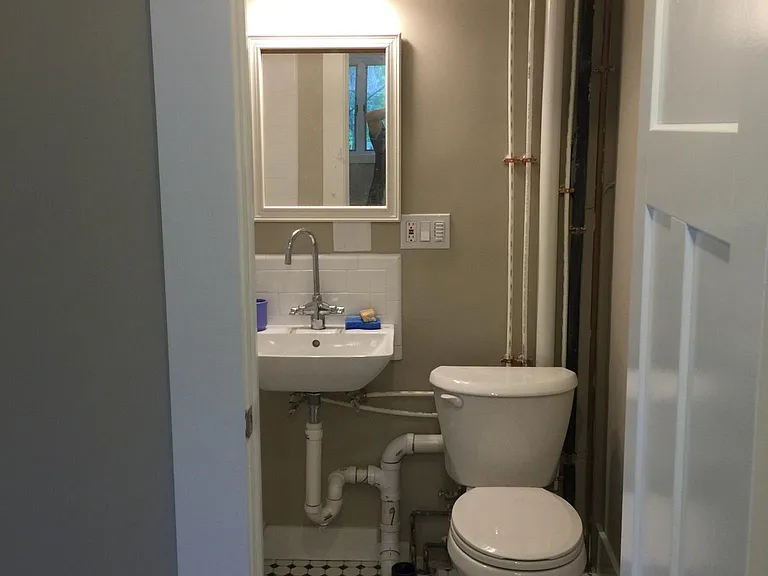 Full bath, with funky art studio touches -- exposed pipes attached to walls with copper