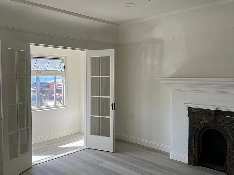 Living room with faux fireplace and sunroom