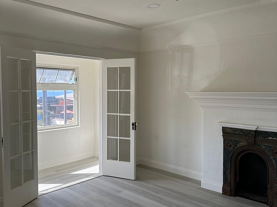 Living room with faux fireplace and sunroom