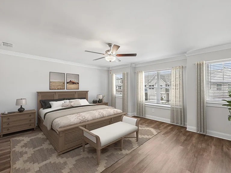 The elegant primary bedroom featuring a plush bed, stylish nightstand, and accent chair.