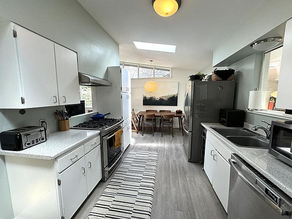 Kitchen with stainless appliances (dual fuel range), new dishwasher, two skylights, and vaulted ceilings.