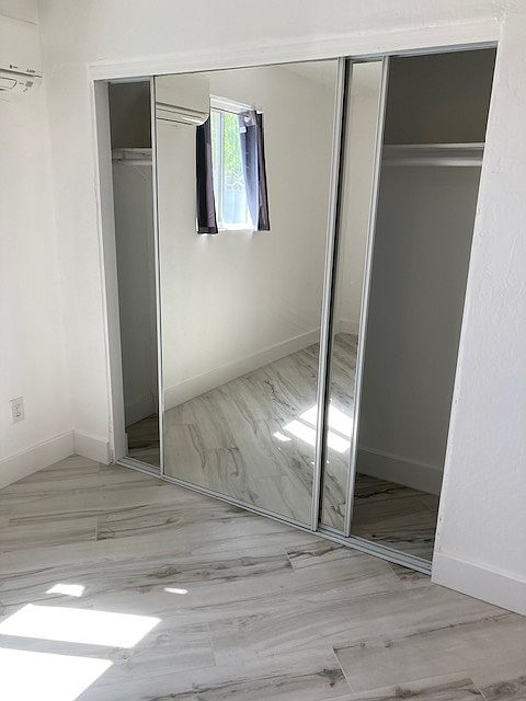 Master/King size bed and closet with mirror wardrobe sliding doors and shelving.