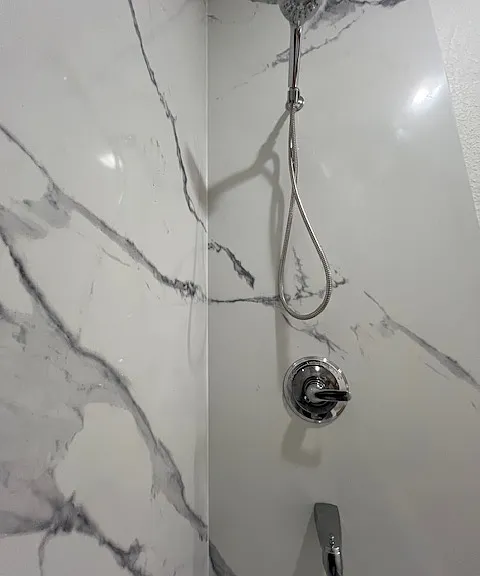 Closeup of the gorgeous walls of the shower and tub with wand shower head in the BRAND NEW bathroom