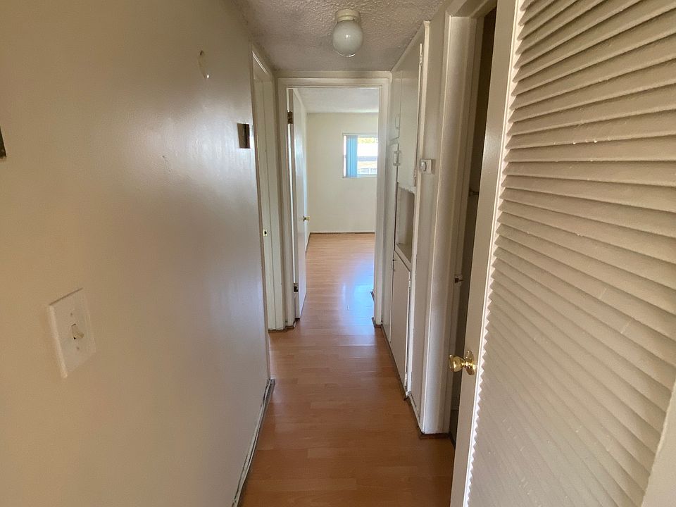 View of hall way leading to master bedroom on left, second bedroom straight ahead and bathroom and storage cabinets on right.