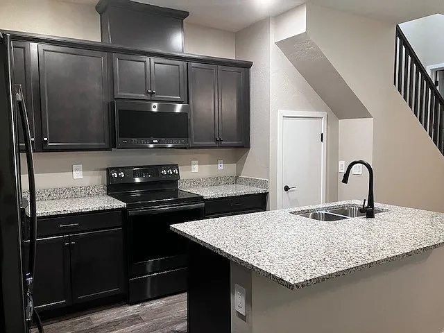 Beautiful kitchen with granite countertops, 42" cabinets, GE Cafe stainless steel appliances, a center island & ample storage,.