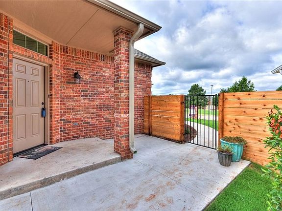 Gated privacy entry with patio seating near the front door.