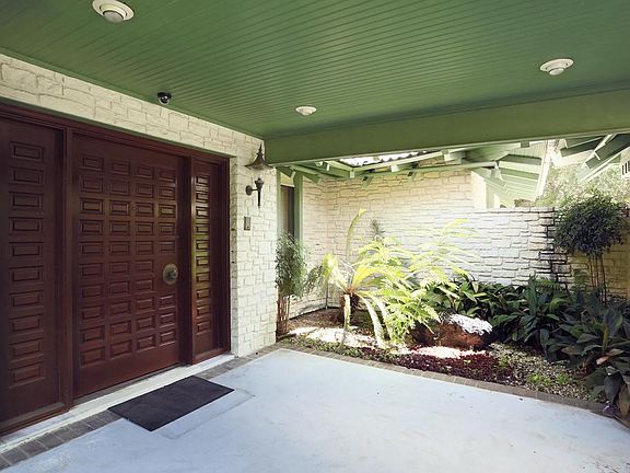 Courtyard that invites you in. Tasteful solid wood door!