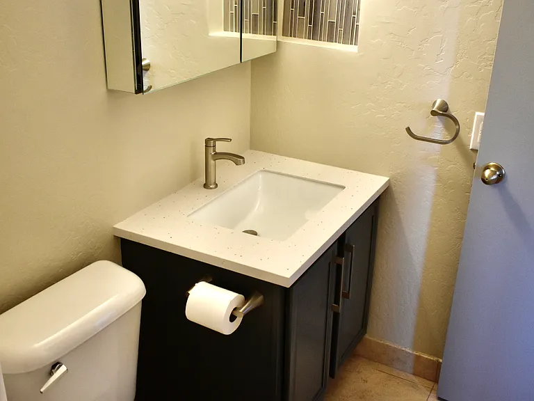 Master Bathroom - Solid-surface countertop, sink, mirrored vanity cabinet, light fixture, faucet and fixtures installed Aug 2024