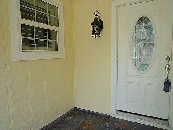 Wrought iron gate entry with slate tiled front porch and pretty leaded glass front door. Gutters in front & back.