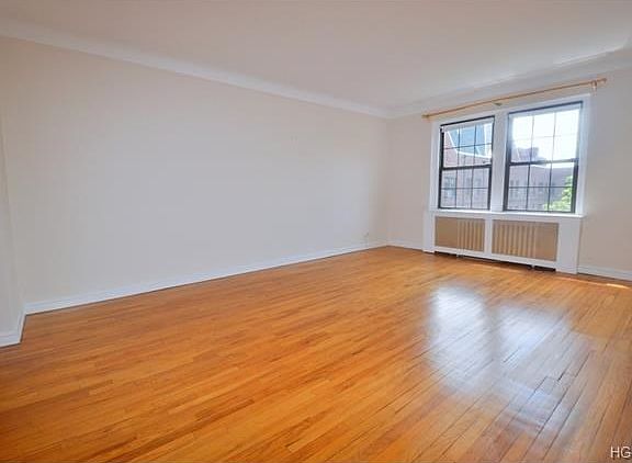 The living room has treetop views and overlooks the quiet courtyard. There are two arched opening, o