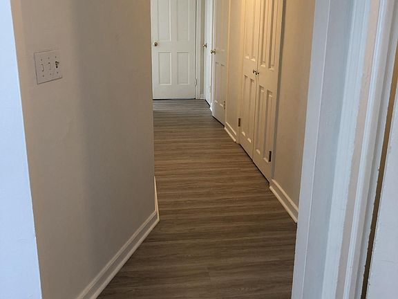 Hallway lined with closets; new flooring.
