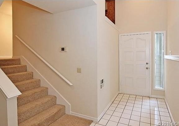 Large entry hall with a half staircase up to the living area, kitchen, and one of the two bedrooms.