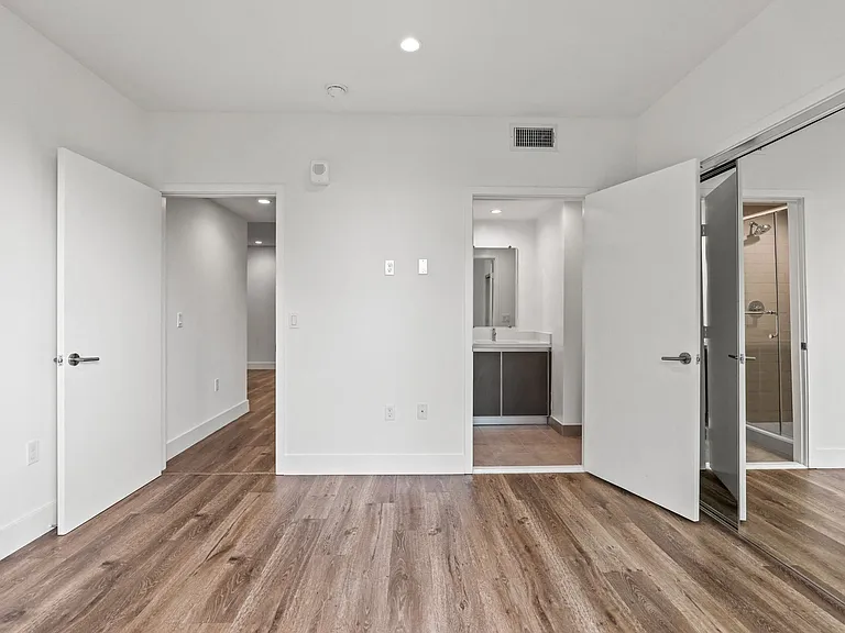 Bedroom with Mirrored Closet, Recessed Lighting, Vinyl Flooring, and Bathroom