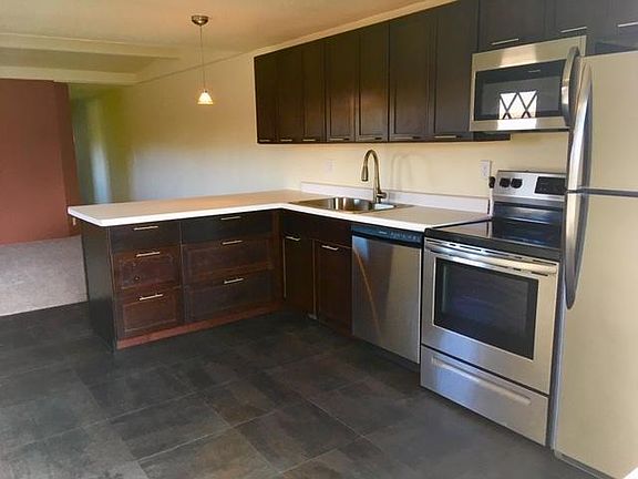 Kitchen with living room and hallway in background
