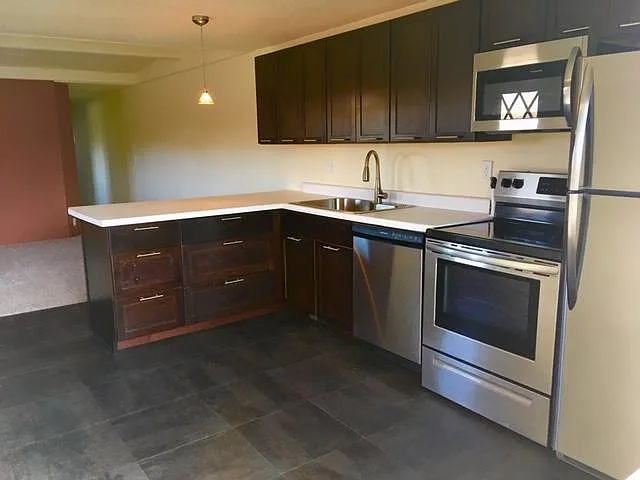 Kitchen with living room and hallway in background
