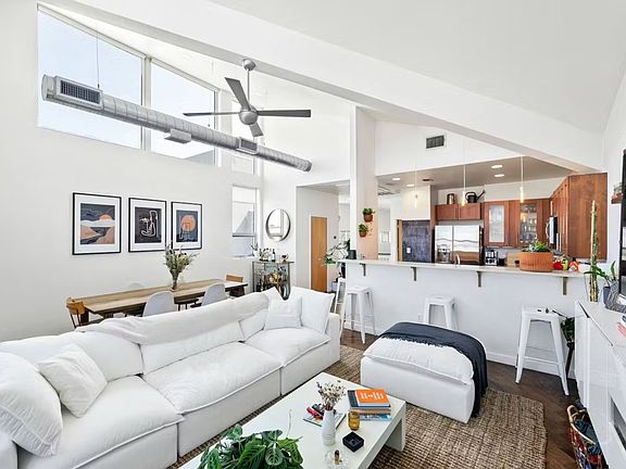 Large open living room with the best natural light with high two story ceilings and west + north facing windows. Your house plants will thrive!