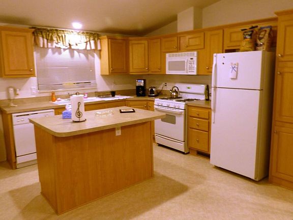 Modern kitchen with dishwasher, refrigerator, coffeemaker and bean grinder, microwave, air fryer, toaster and blender