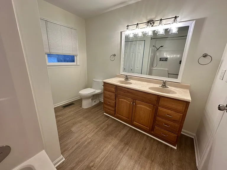 This is the second bathroom in the home. The spacious bathroom features a tub/shower combo, two sinks, plenty of vanity storage, a Toto toilet, a window with a view of the back yard, and access to the laundry room - which features even more storage space.