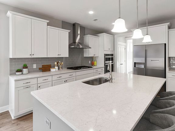 Flex your creativity in this beautiful Kitchen with white cabinets and gray backsplash