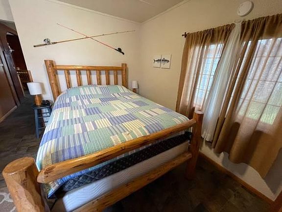 The sleeping area is a cozy retreat, featuring a comfortable queen-size bed frame, perfect for unwinding after a long day.