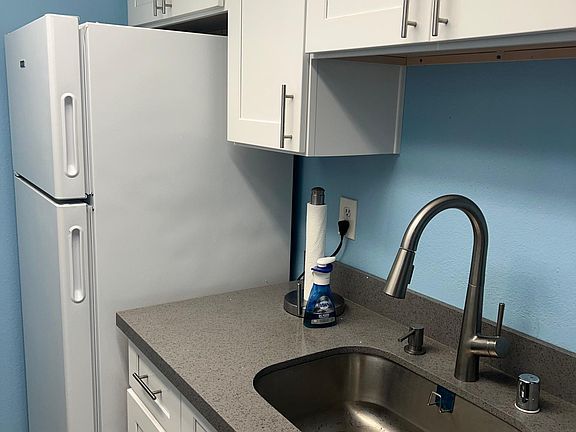 fully remodeled kitchen with newer electric range, over, dishwasher, refrigerator, ducted under cabinet range hood.
