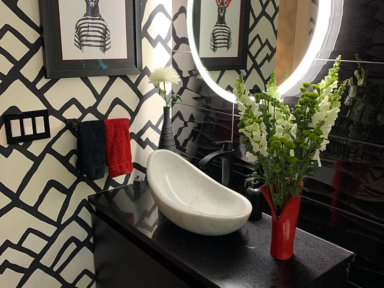 half-bath with quartz countertop, marble basin, and dimmable mirror light