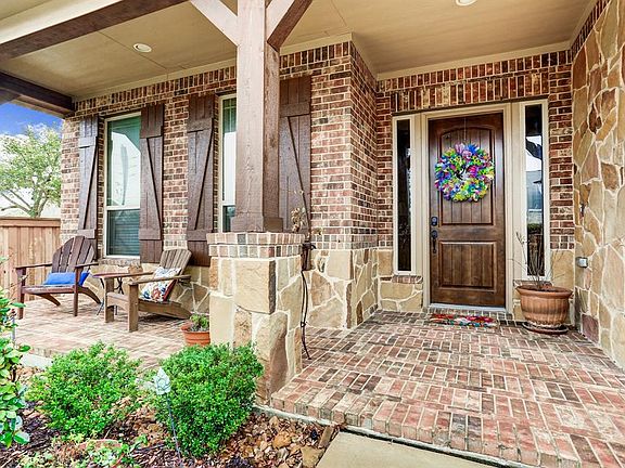 Stone and brick front porch is the perfect place to relax and welcome family and friends.