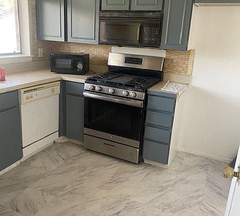 Kitchen opens to den, new vent a hood over range instead of microwave