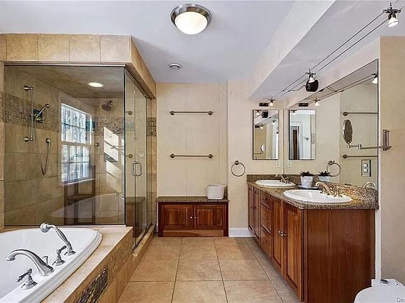 Master bath with steam shower and large heated jacuzzi tub