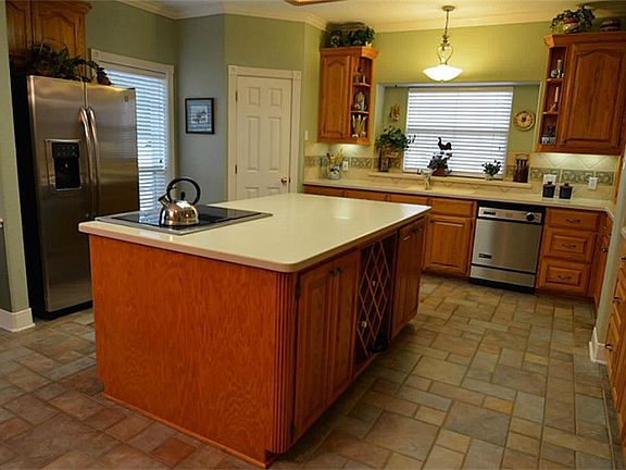 KITCHEN FEATURES CORIAN COUNTER TOPS, CENTER ISLAND WITH COOKTOP/OVEN DROP IN. IT IS PLUMBED FOR GAS FOR YOU SUPER CHEFS THAT REQUIRE IT. ALL CUSTOM SITE BUILT CABINETS  THROUGH OUT THE HOME. WINE RACK FOR YOUR PERSONAL STASH.