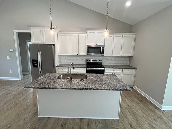 Kitchen with island, granite countertops and stainless appliances