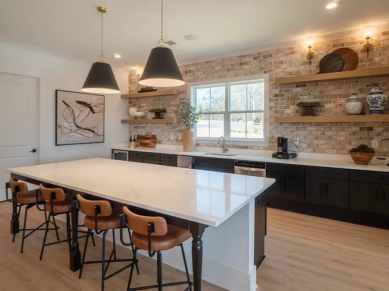 Kitchenette inside the clubhouse with bar seating, mini fridge and sink.