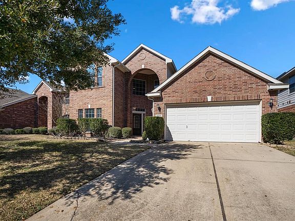 Vibrant blue skies allowed us this show stopper view of the home! Classic neutral brick exterior is complimented by the light neutral trim accents. A mature tree in the yard provides just the right amount of shade & manicured landscaping frames the h