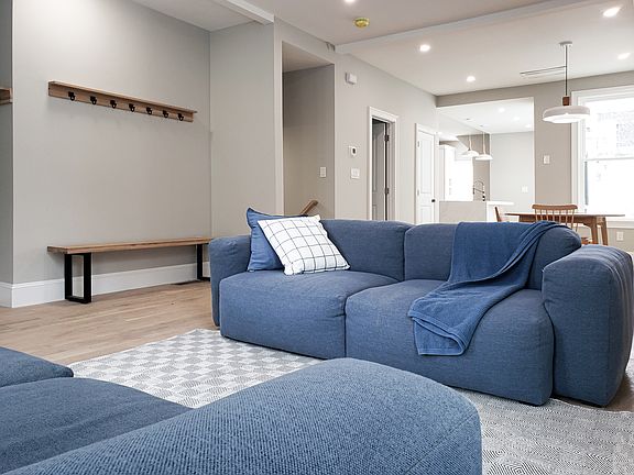 Living room, dining room, and kitchen on the ground floor- 10' tall ceiling, large windows (3' by 7'); designer hay sofa, design white oak table, kitchen with back yard deck;