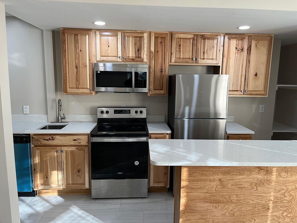 Kitchen with quartz countertop, stainless steel appliances, and peninsula