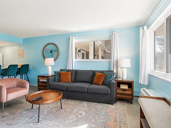 Sink into the soft couch, bask in the natural light, and enjoy the cheerful, welcoming energy that makes this space feel like a true getaway.
