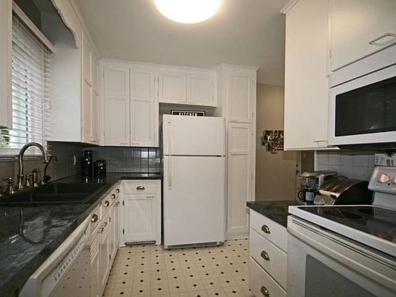 Look out the large window as you stand at the sink.  The crisp clean white kitchen has new counter tops, sink and faucet.  The cabinets have just been repainted and new stylish hard wear installed. The appliances are only a few years old.