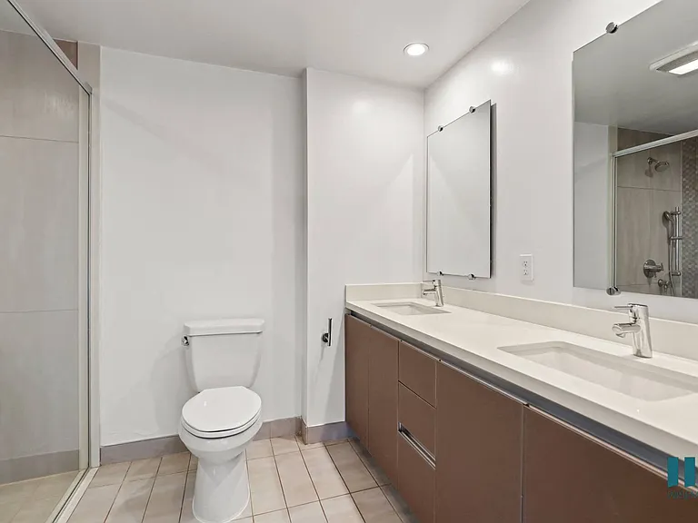 Bathroom with Walk-In Shower, Double-Sink Vanity, and Cabinet Storage