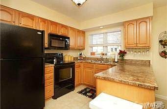 Maple cabinetry, black appliances - frig remains.