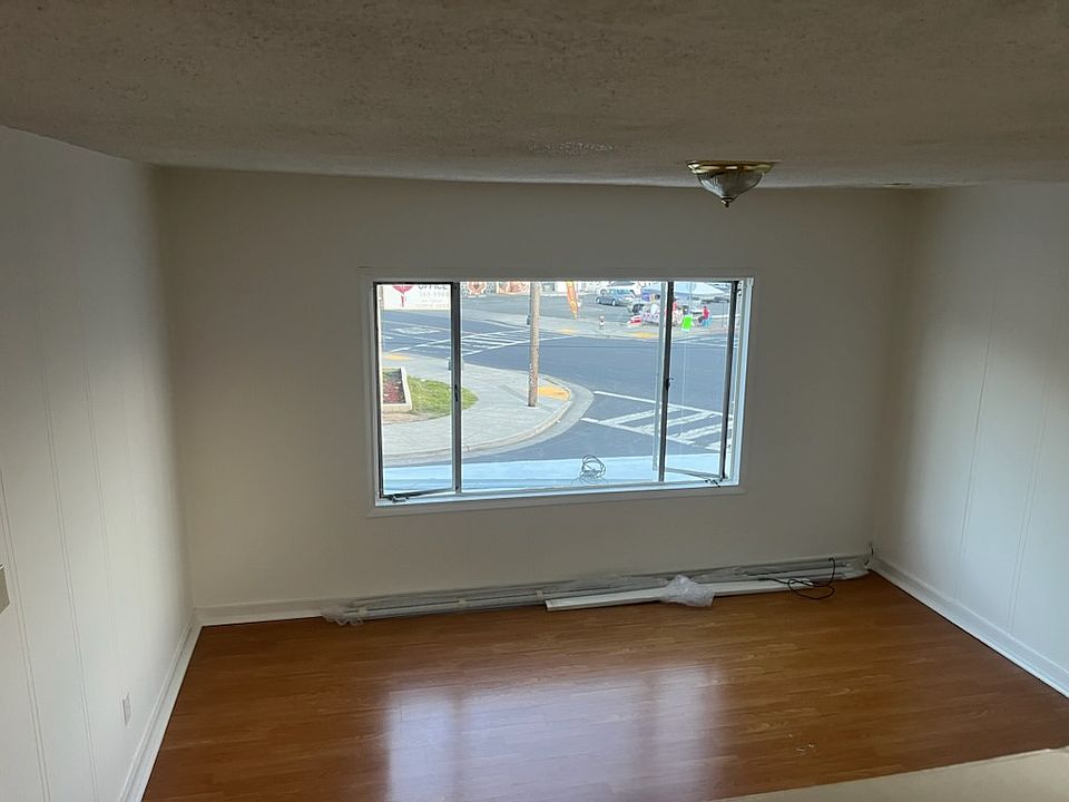 View from second floor to lower living room. Hardwood floor and new Blinds on picture window.