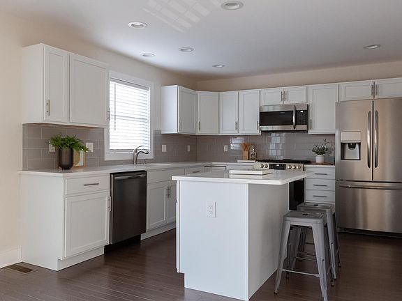 Shaker cabinets, tile backsplash, quartz countertops, island + breakfast bar, gas range, french door refrigerator, dishwasher.