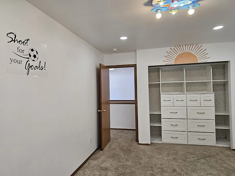 Kids bedroom, with custom made shelves with big drawers. Very bright and lively room.