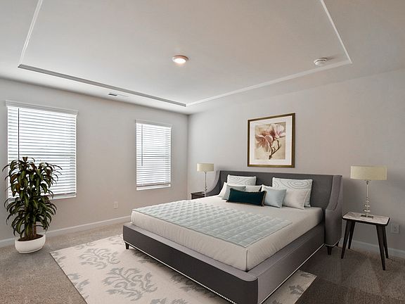 The primary suite features large windows and a luxurious bathroom.