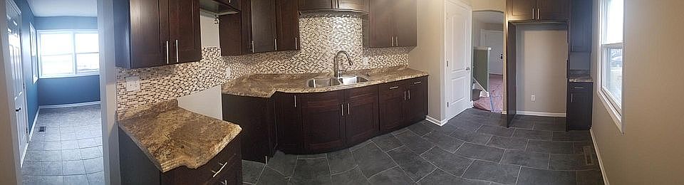 Entrance way from the back door into the kitchen and entrance way to the living room just past the staircase.