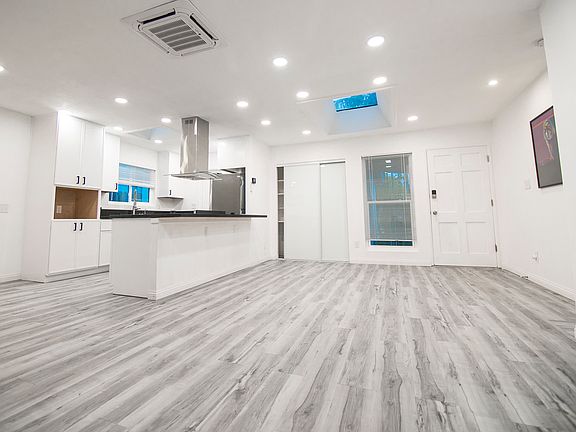 Living rm with skylight, new flooring, and new kitchen with bar area. Mini Spit in ceiling for AC and heat. Recessed lights on dimmers.