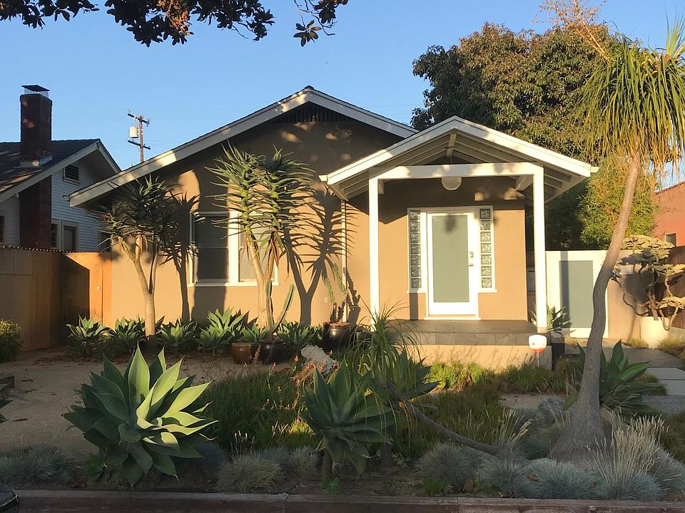 Front of the house from the street. Mature magnolia tree and eco-friendly landscaping.