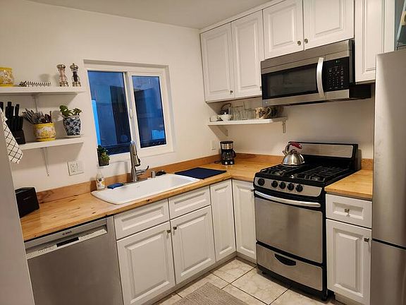 Kitchen with gas grill, full size refrigerator, microwave and dishwasher.