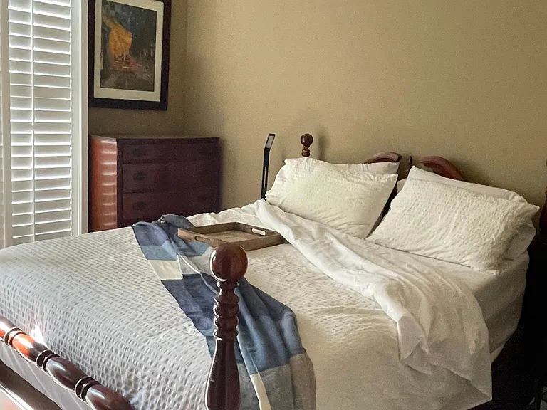 Master bedroom with a queen bed and two dressers, a walk in closet and a security safe.